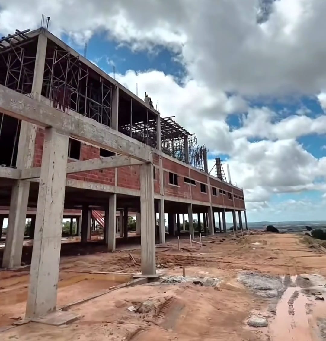 Obra do Hospital Municipal de Garanhuns em construcao, estrutura de concreto e tijolo sob ceu azul