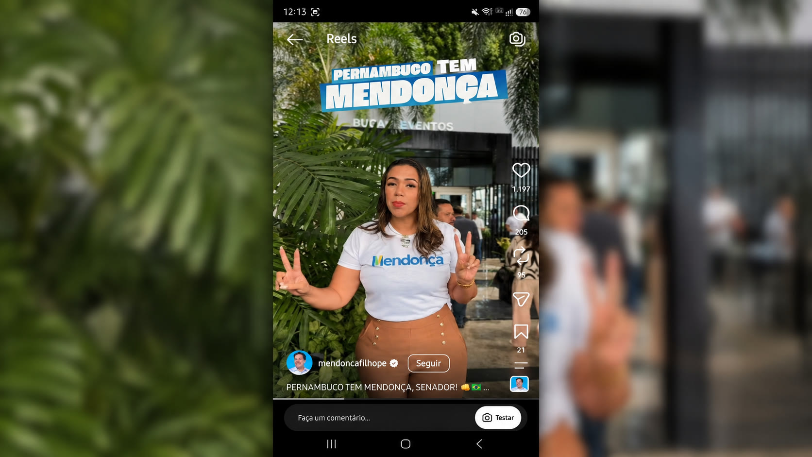 Mulher com camisa de Mendonça Filho diante do Bugan Hotel, em frame do Reel oficial com a frase Pernambuco tem Mendonça