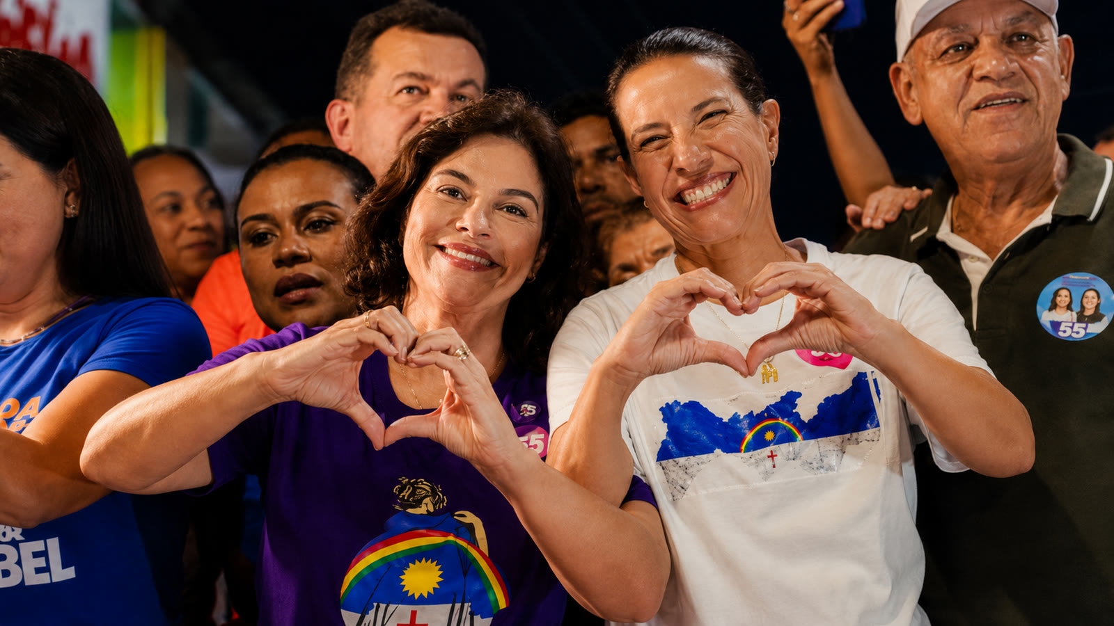 Raquel Lyra e Priscila Krause sorriem e formam coracoes com as maos durante evento politico