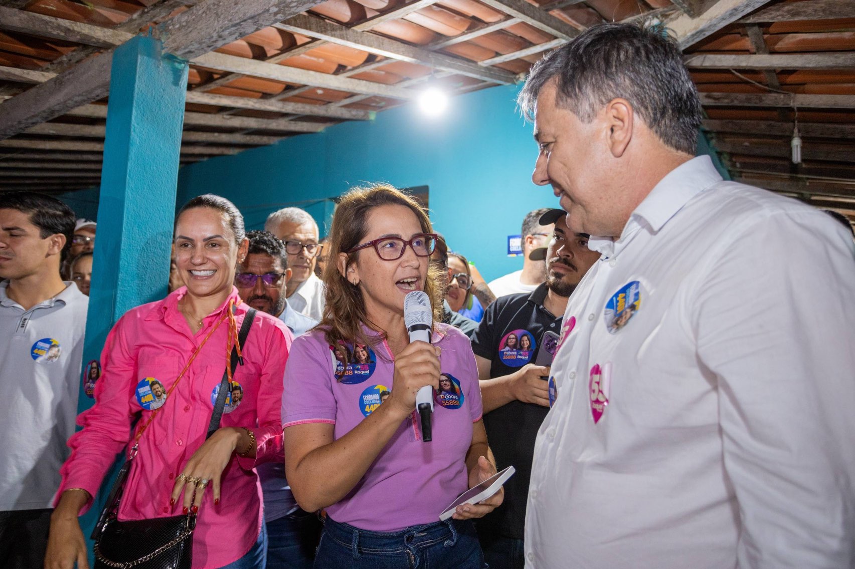 Débora Almeida fala ao microfone enquanto Marcos Patriota a acompanha