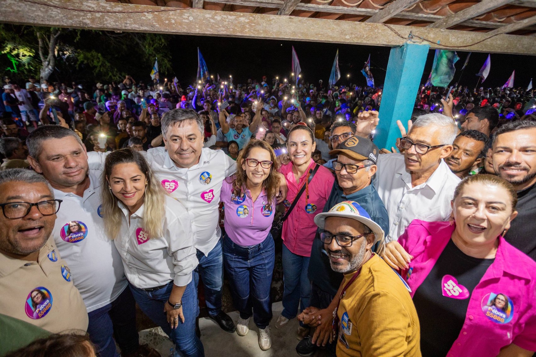 Marcos Patriota, Débora Almeida e participantes posam com a rua cheia ao fundo