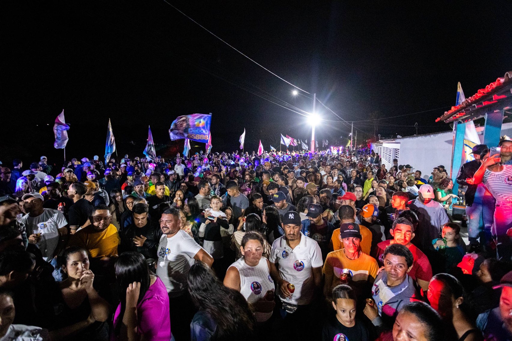 Fotografia mostra o público reunido em frente ao palco no povoado de Santa Rita