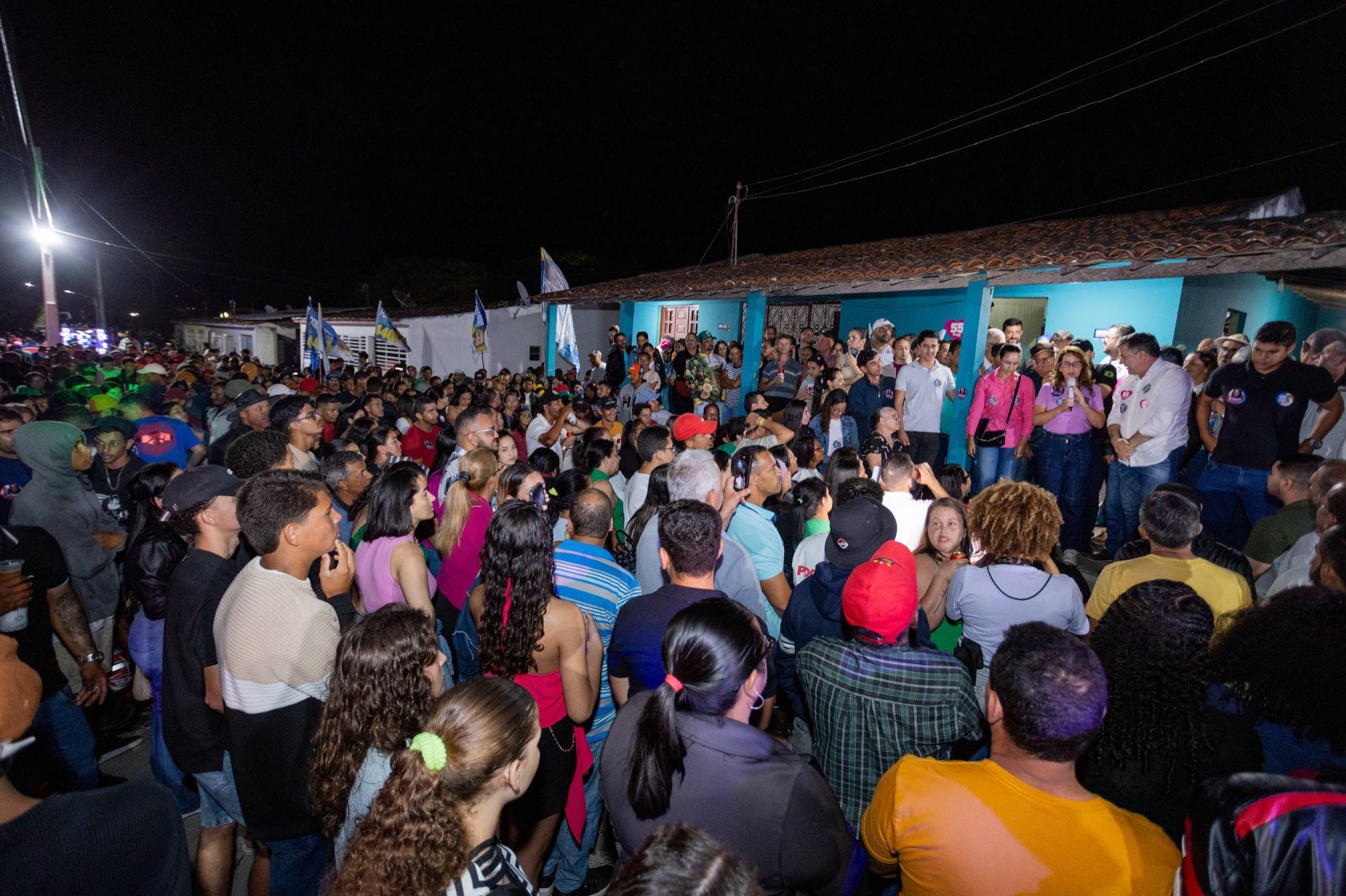 Público ocupa a rua diante de uma casa azul usada como palco no encontro em Santa Rita